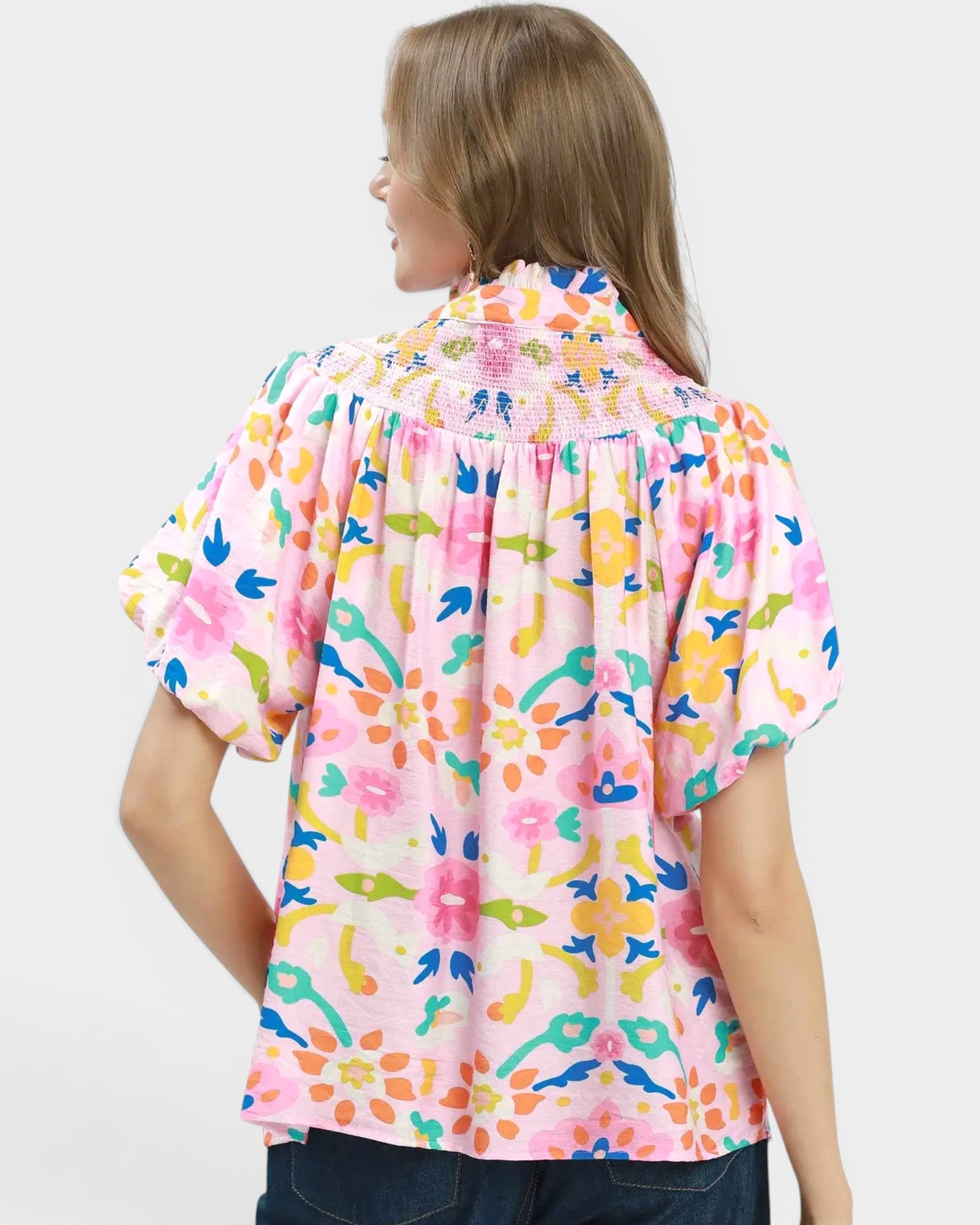Woman wearing a colorful floral blouse on a white background
