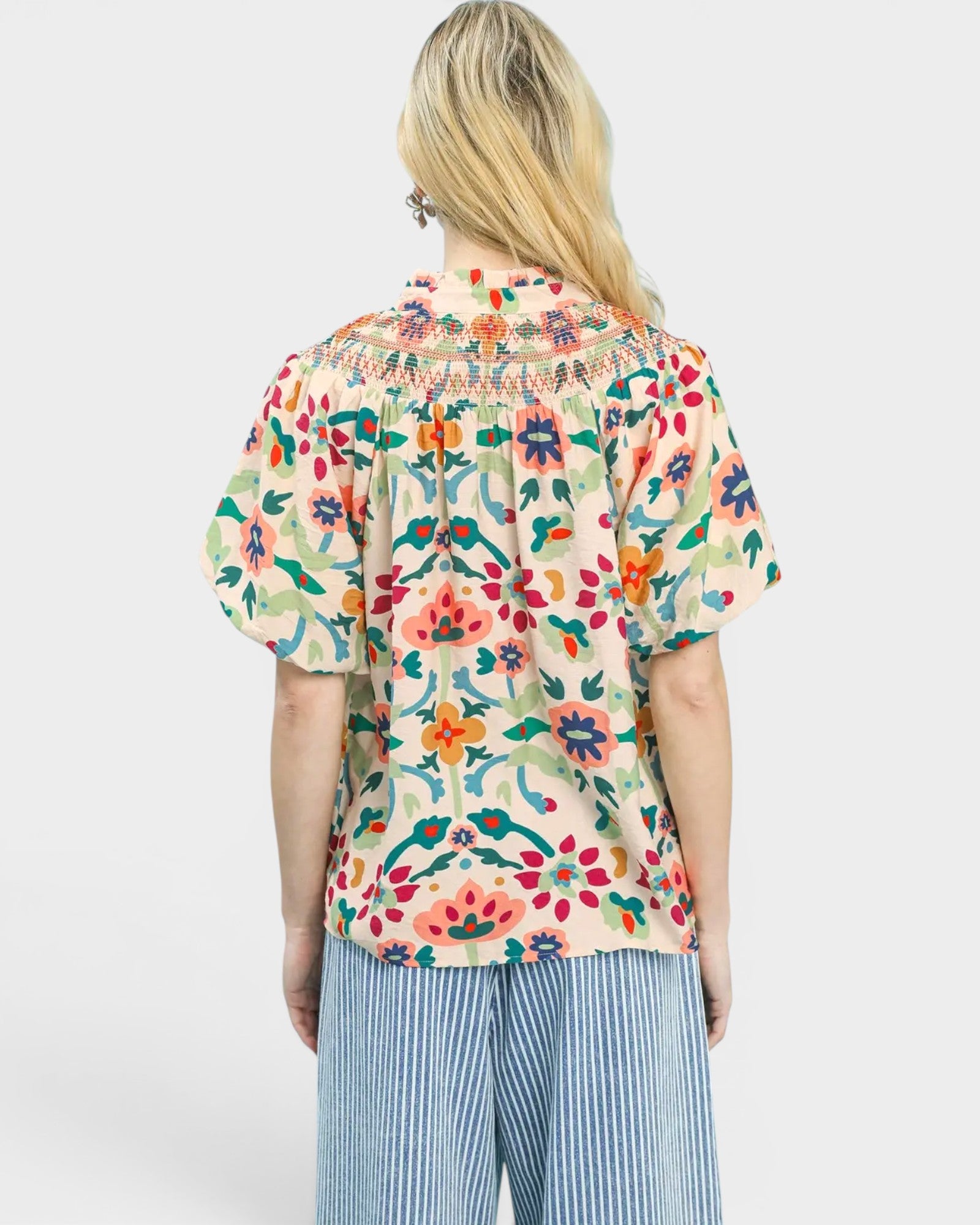 Person wearing a colorful floral shirt on a white background
