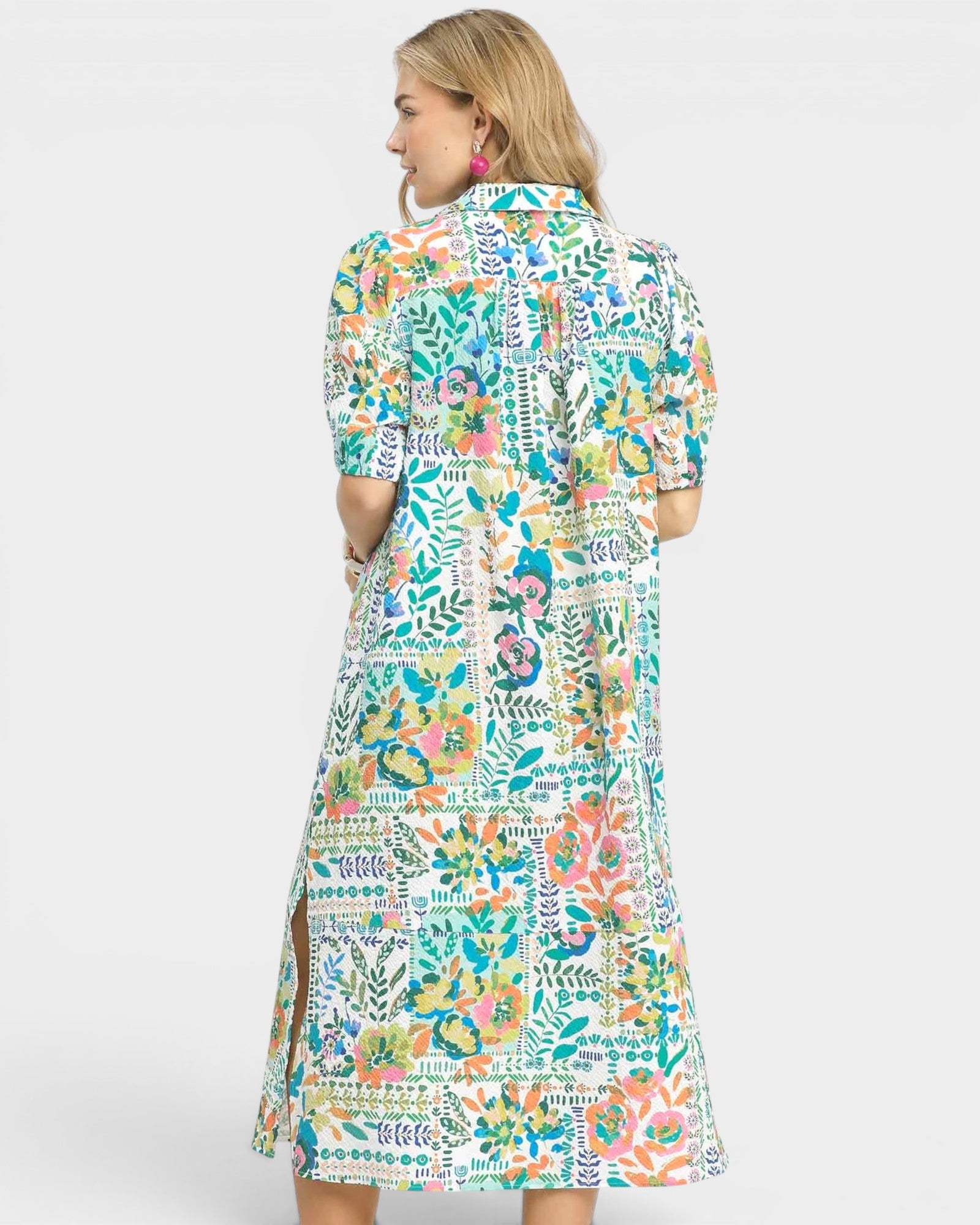 Woman wearing a colorful floral dress on a white background