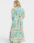 Woman wearing a colorful floral dress on a white background