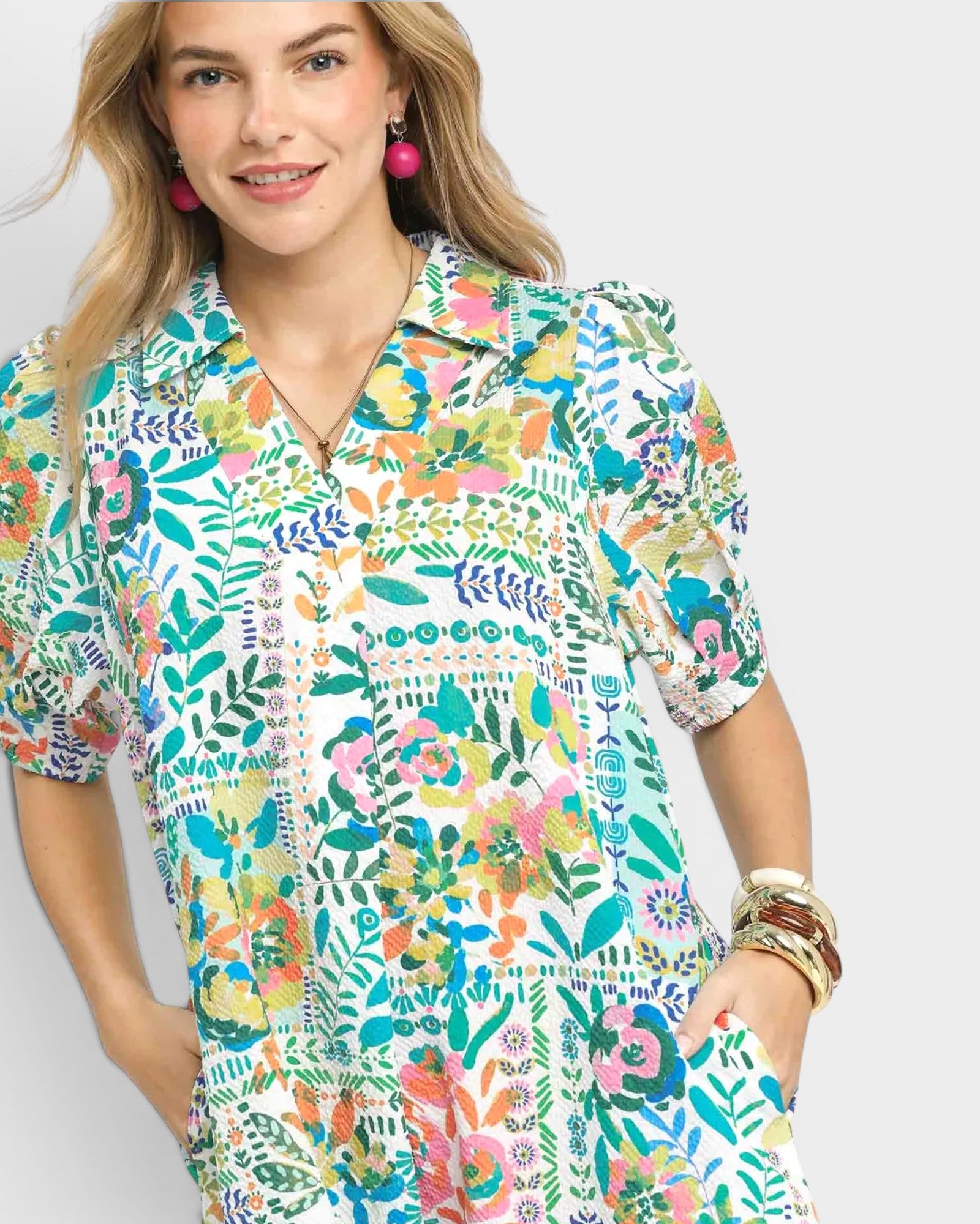 Woman wearing a colorful floral patterned shirt on a white background