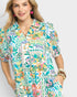 Woman wearing a colorful floral patterned shirt on a white background