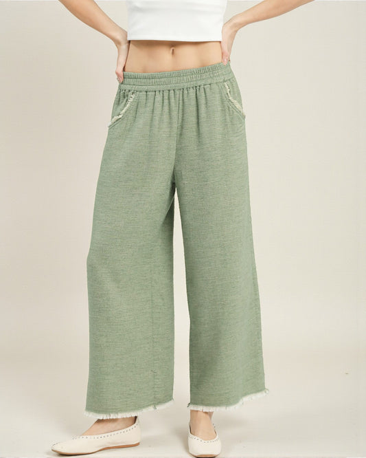 Green wide-leg pants worn by a person on a plain background