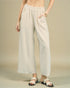Person wearing light-colored wide-leg pants on a beige background
