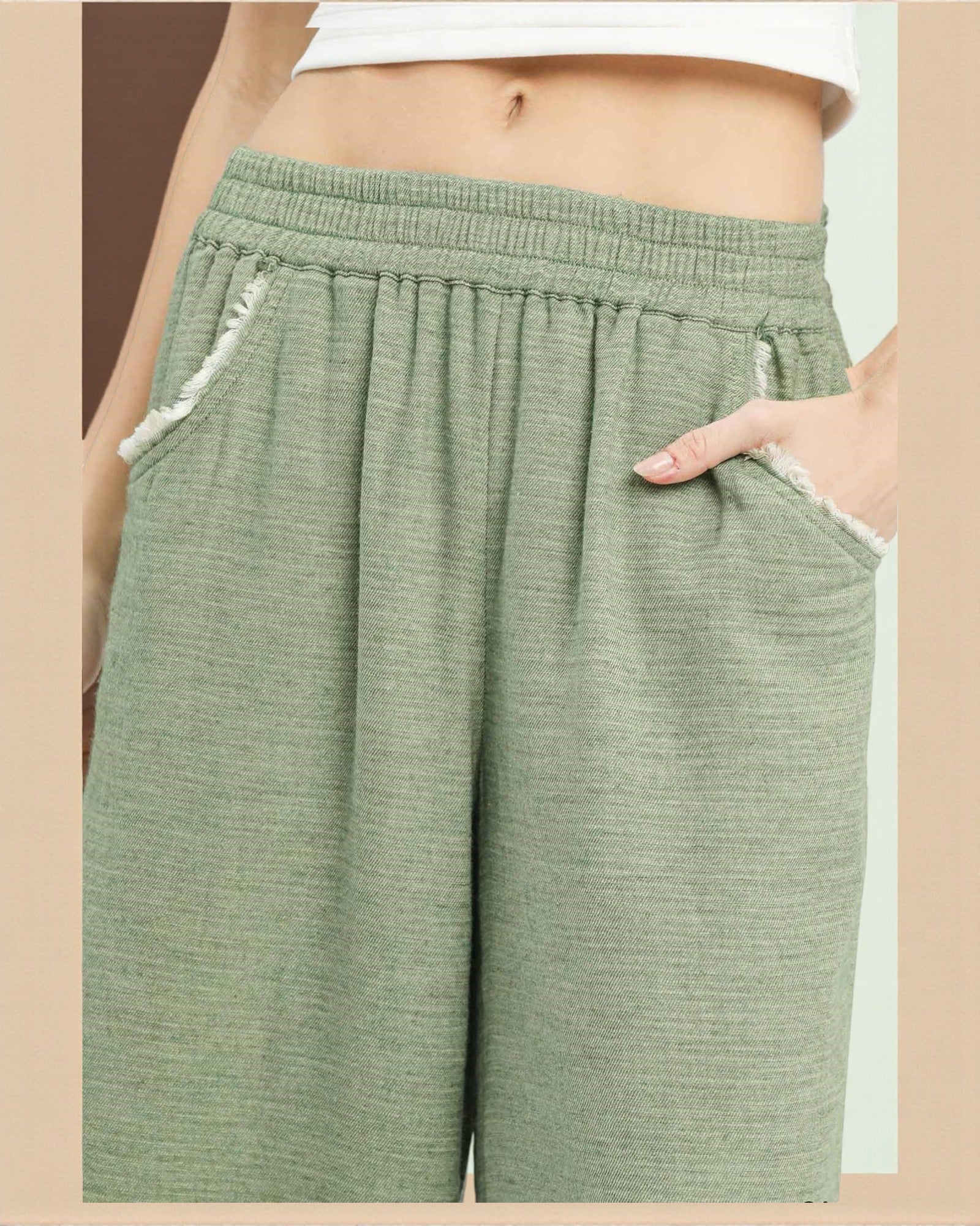 Green shorts worn by a person on a beige background