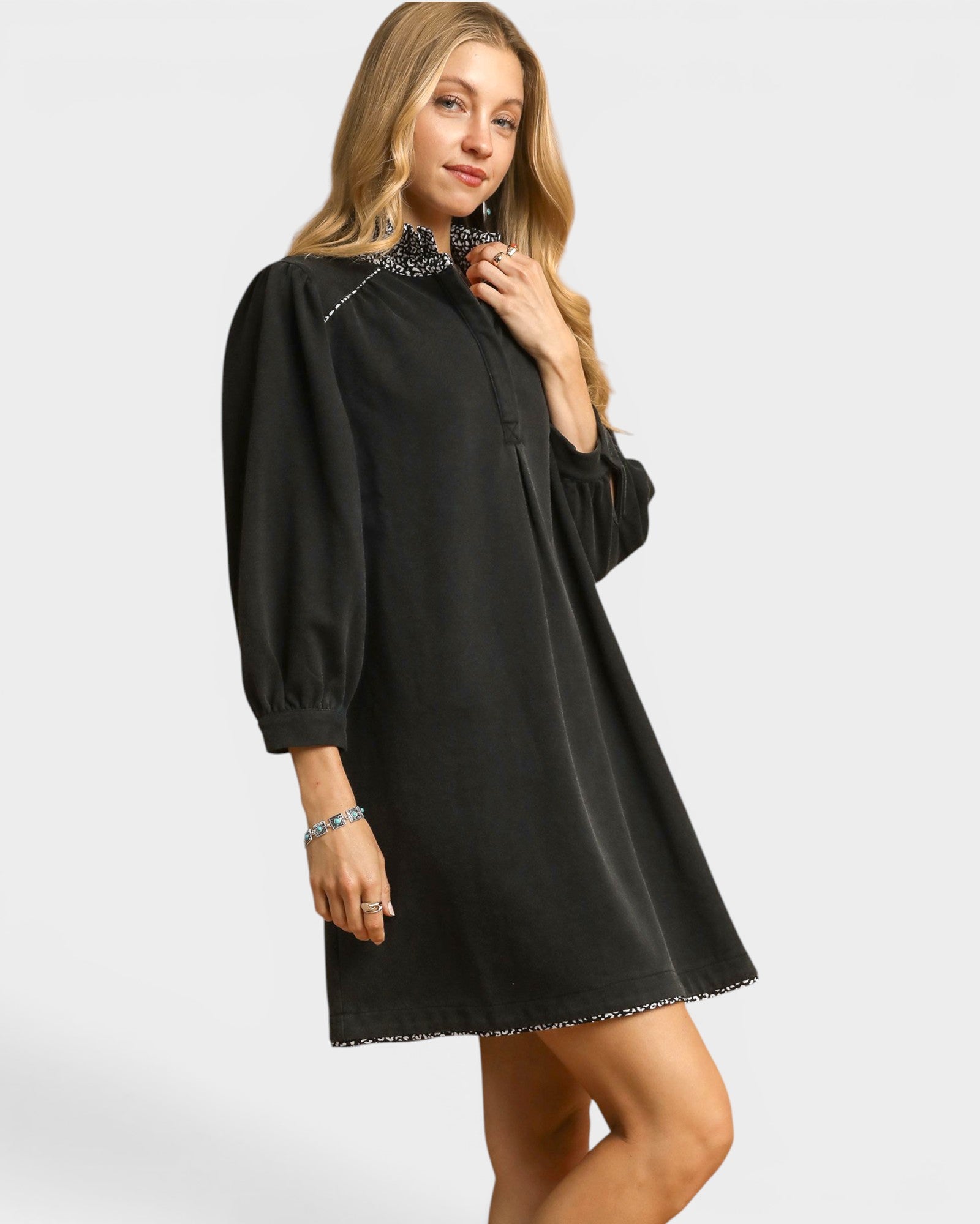 Woman wearing a black dress with lace details on a white background