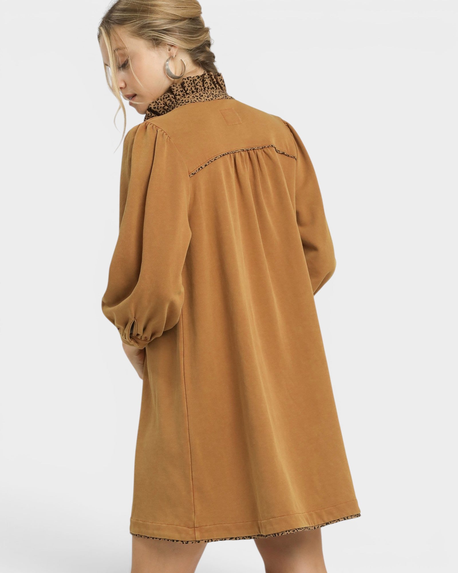 Brown dress with intricate detailing on a plain background