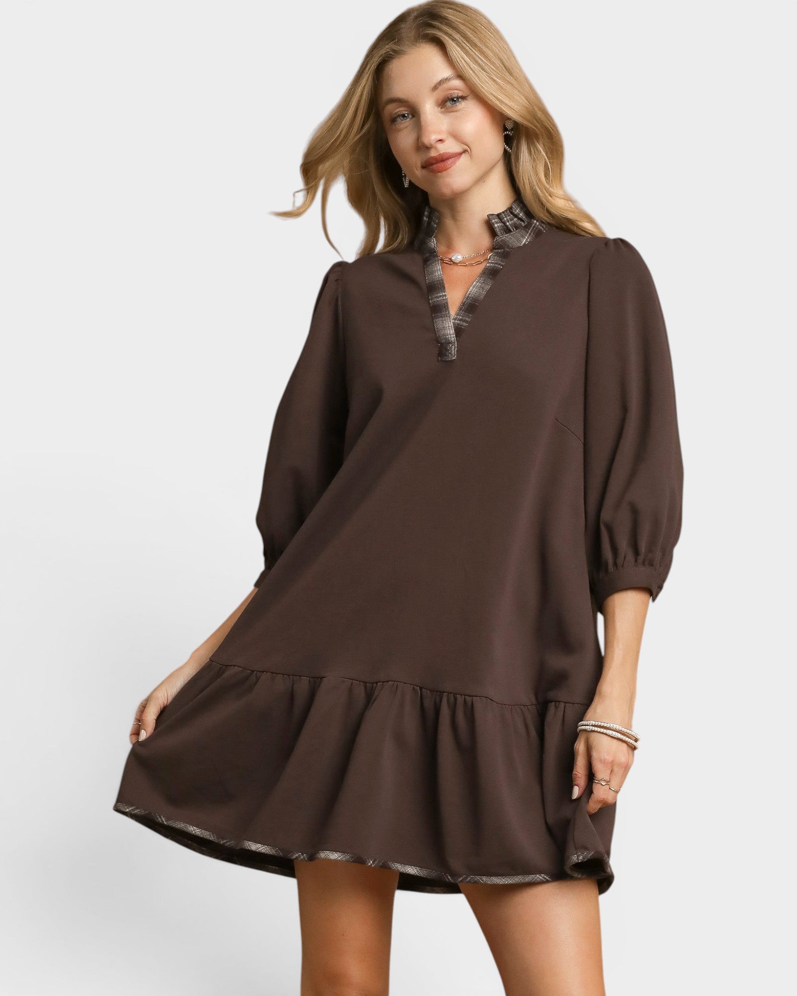 Woman wearing a brown dress with a white background