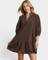 Woman wearing a brown dress with a white background