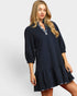 Woman wearing a navy blue dress with a white background