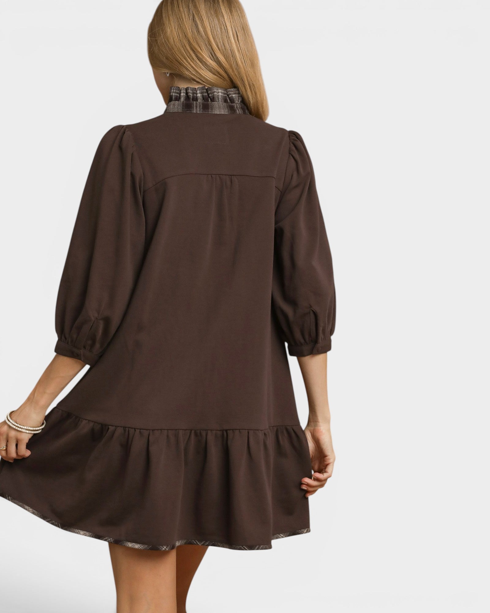 Brown dress with a plaid collar worn by a person on a white background