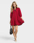 Woman wearing a red dress with a black collar on a white background