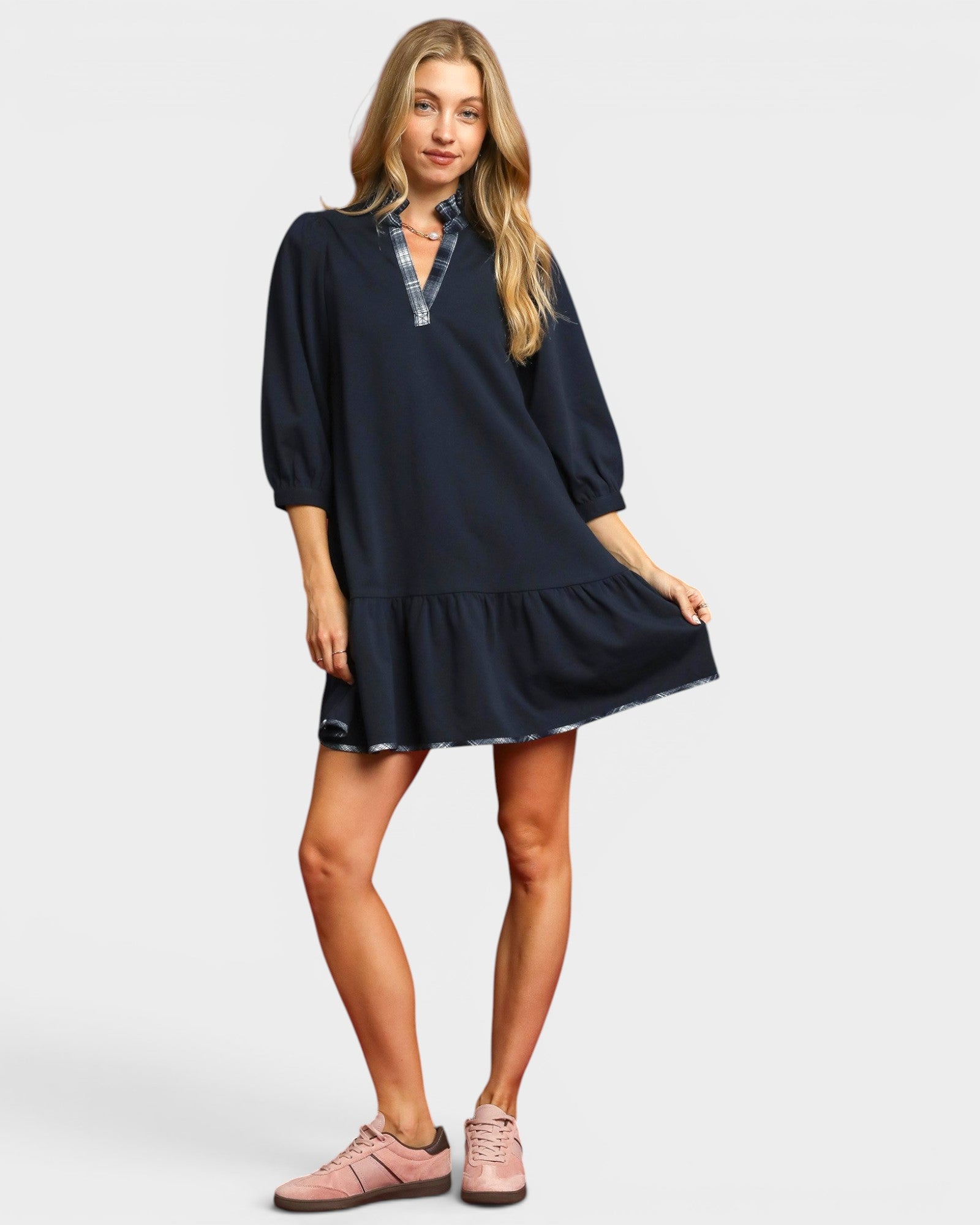 Woman wearing a navy dress with a white background