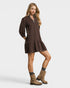 Woman wearing a brown dress and boots on a white background