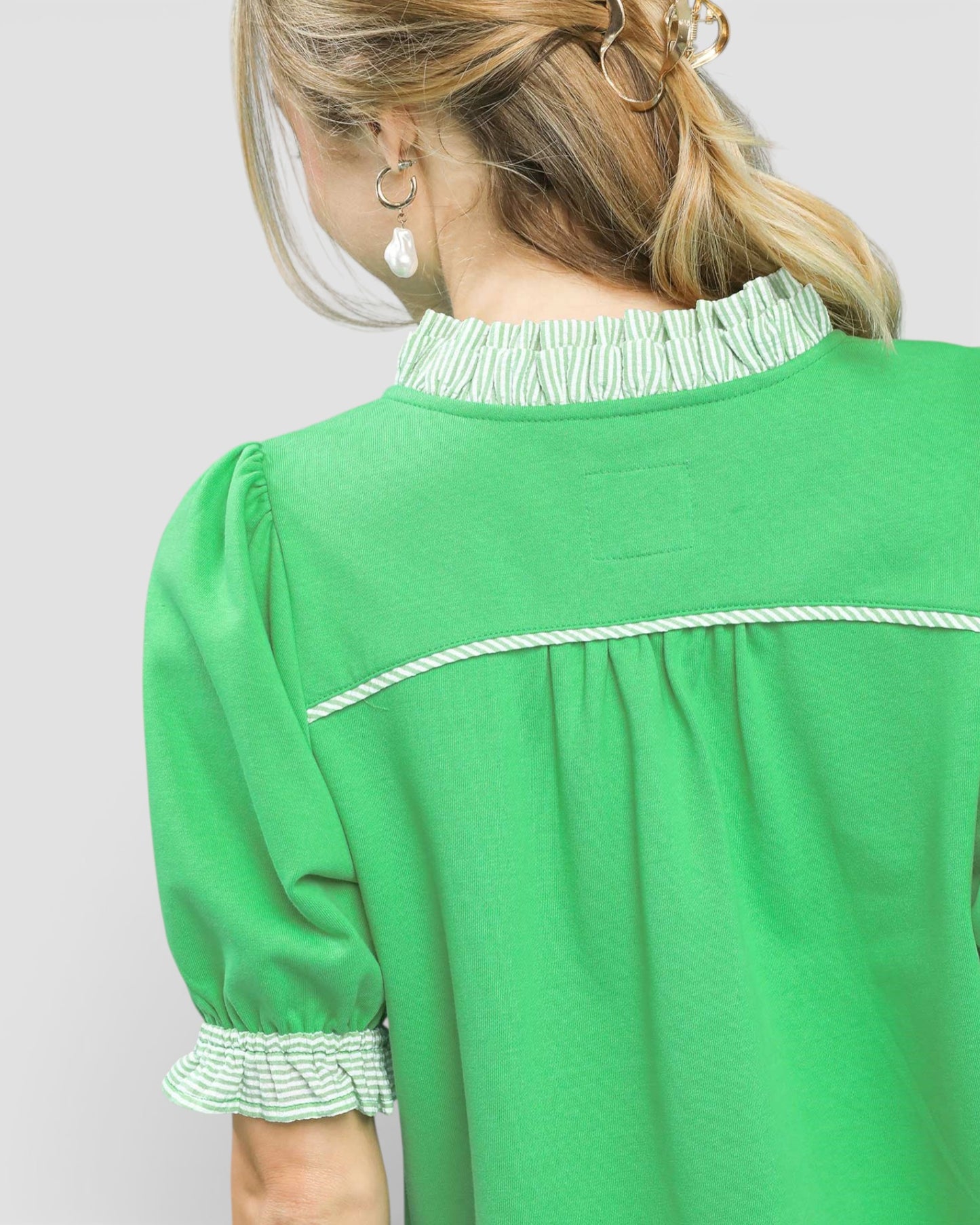 Green dress with white trim on a plain background