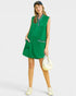 Woman wearing a green sleeveless dress with a white background