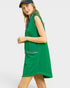 Woman wearing a green sleeveless dress with a white background