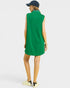 Woman wearing a green sleeveless dress with a white collar on a light gray background