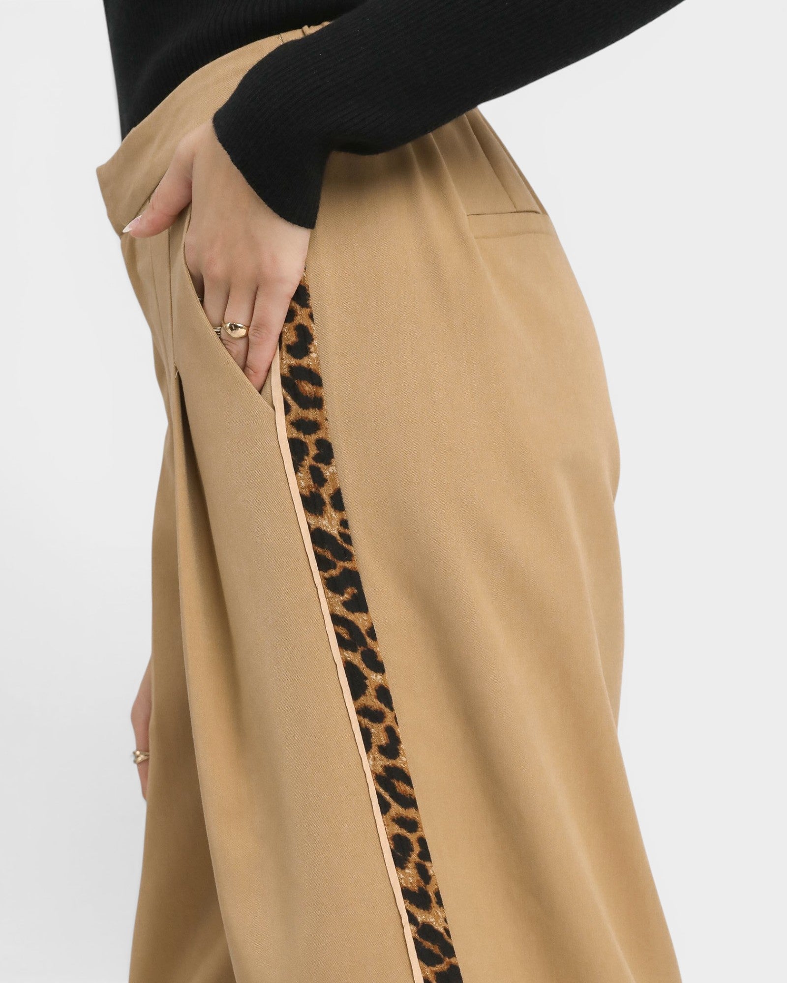 Tan pants with a leopard print side stripe on a white background