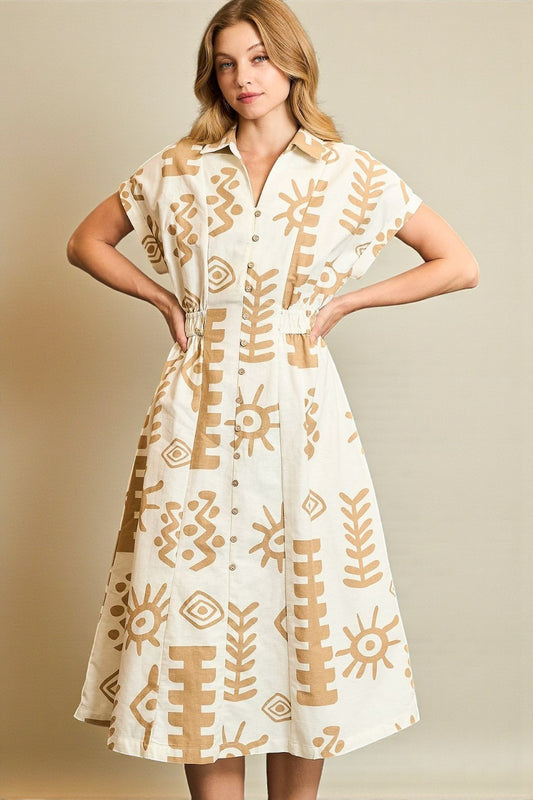 Woman wearing a white dress with gold patterns against a beige background