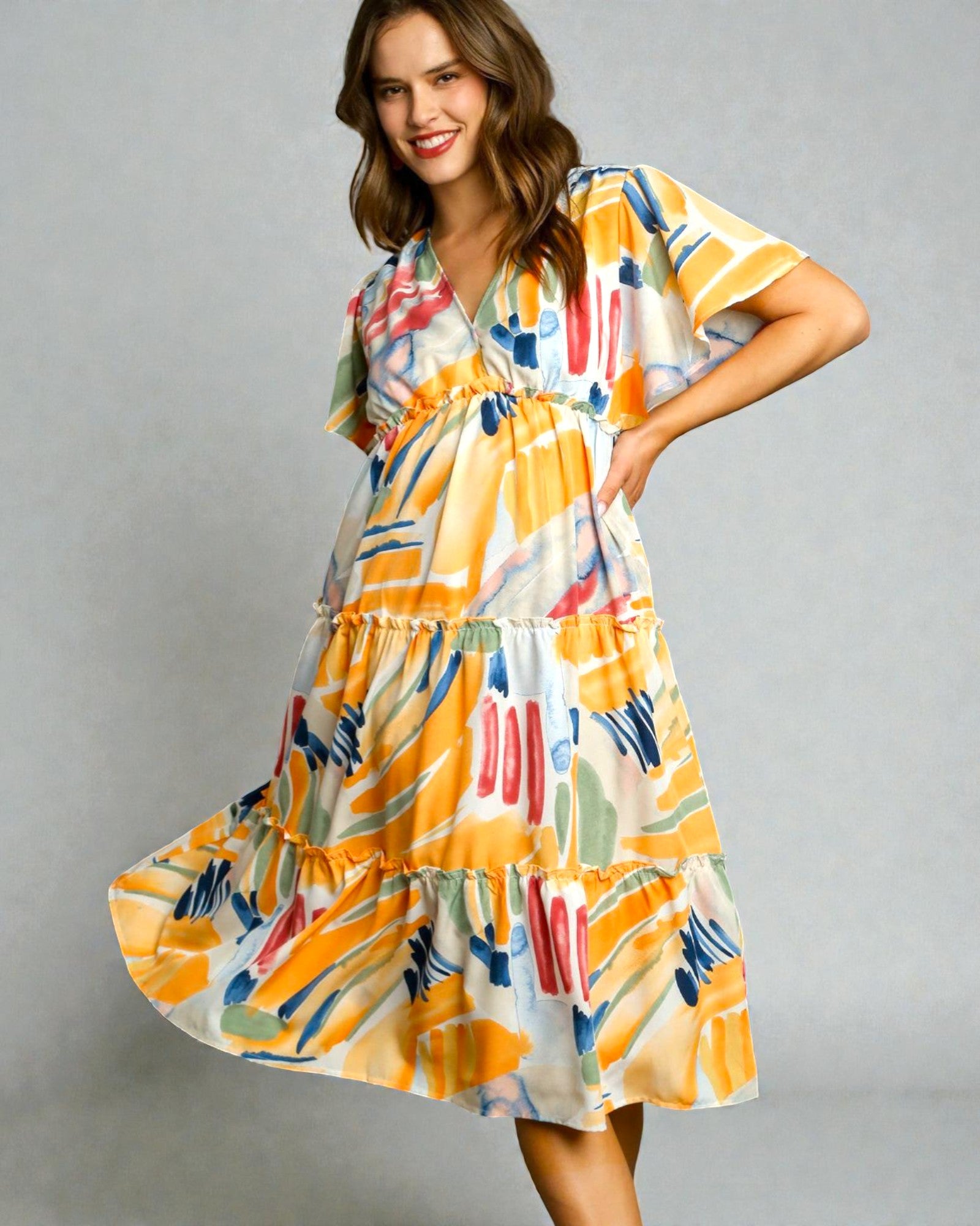 Woman wearing a colorful dress with abstract patterns on a gray background