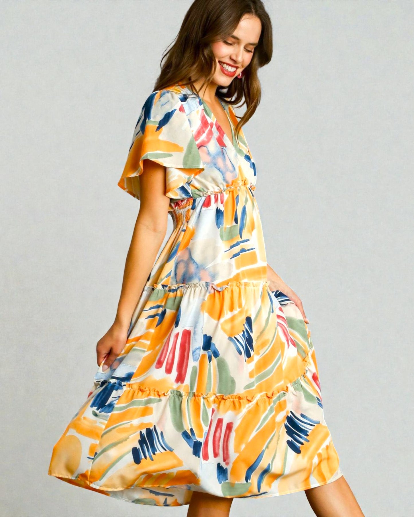 Woman wearing a colorful dress with a plain background