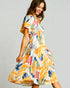 Woman wearing a colorful dress with a plain background
