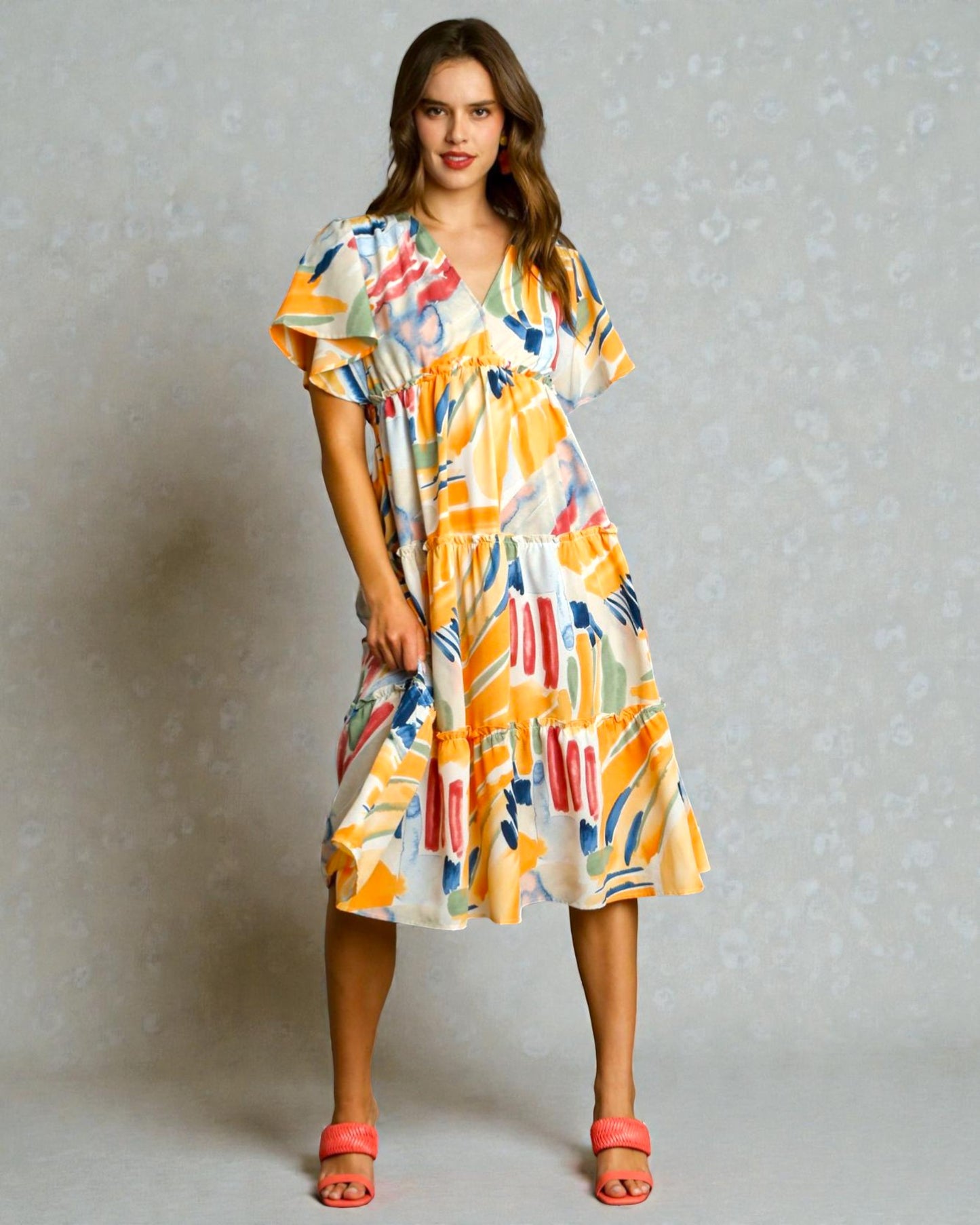 Woman wearing a colorful patterned dress against a neutral background