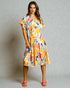 Woman wearing a colorful patterned dress against a neutral background