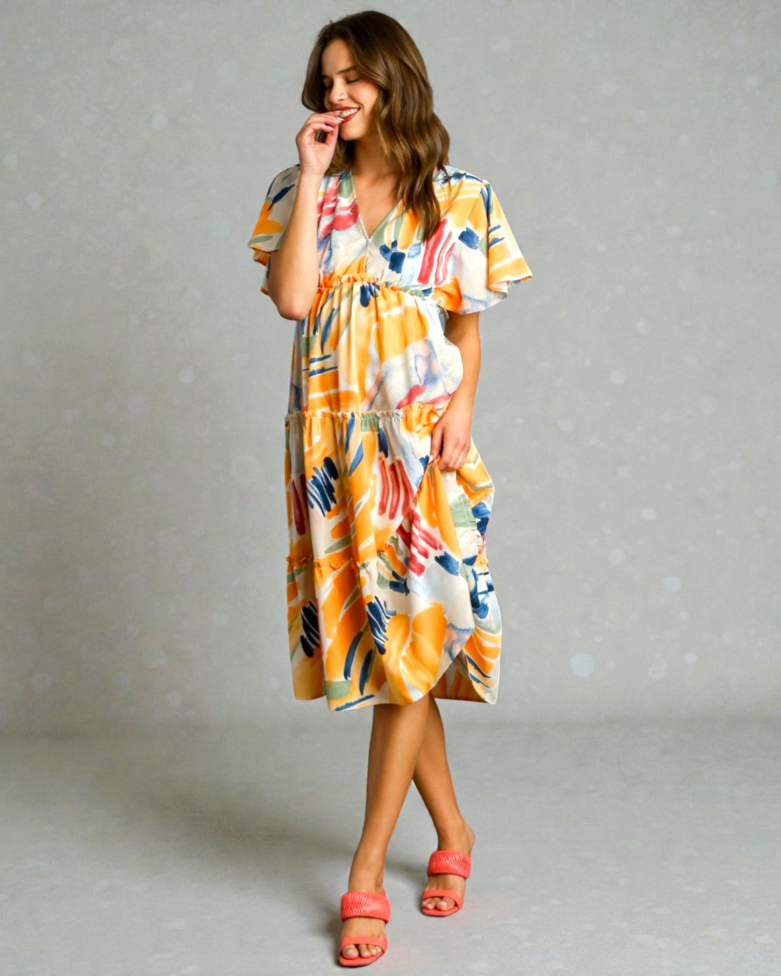 Woman wearing a colorful dress with a plain background
