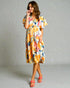Woman wearing a colorful dress with a plain background