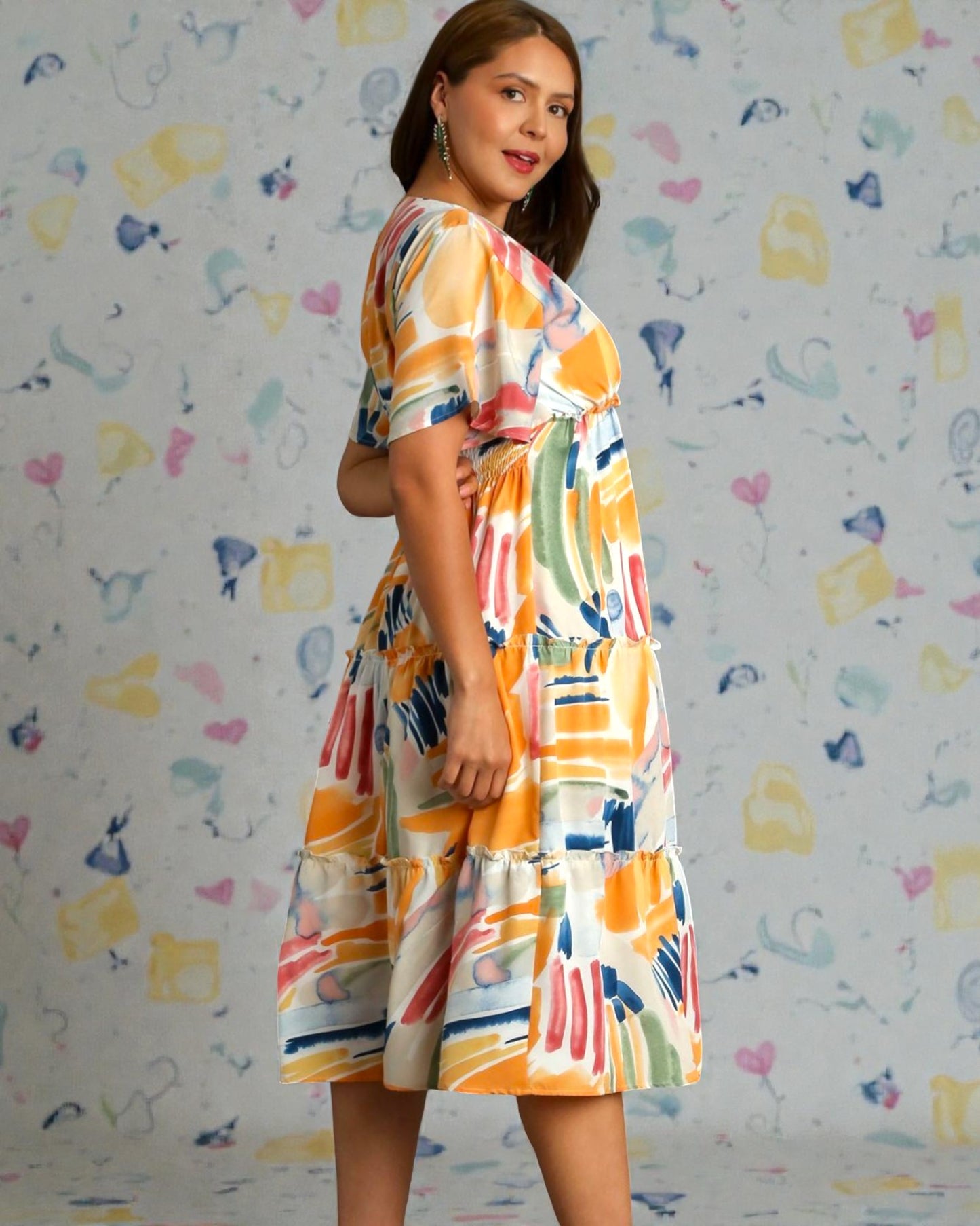Woman wearing a colorful dress against a patterned background