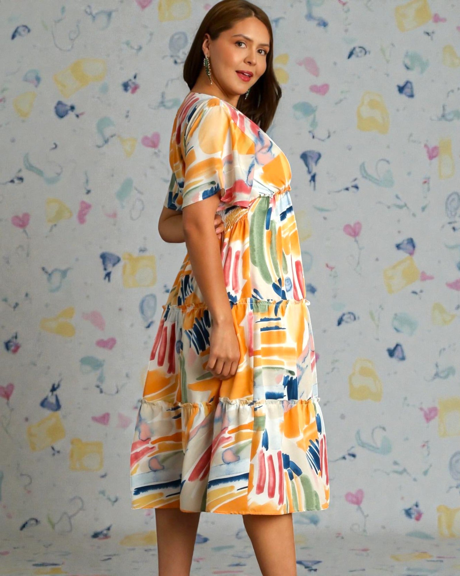 Woman wearing a colorful dress against a patterned background