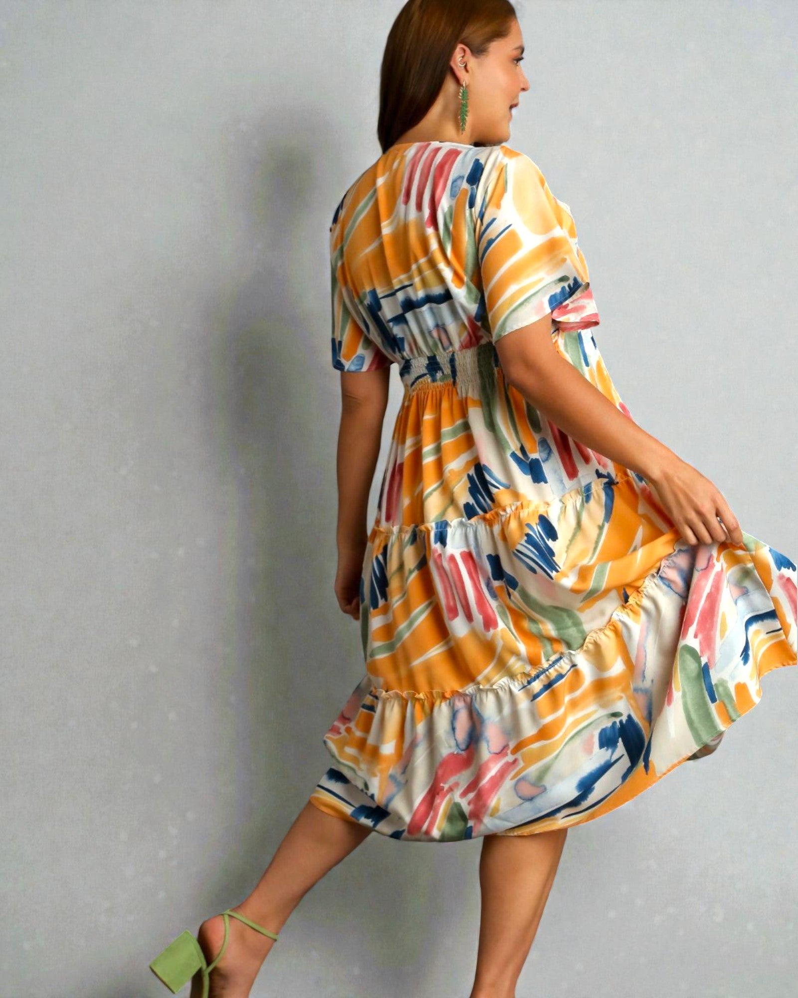 Woman wearing a colorful dress against a gray background