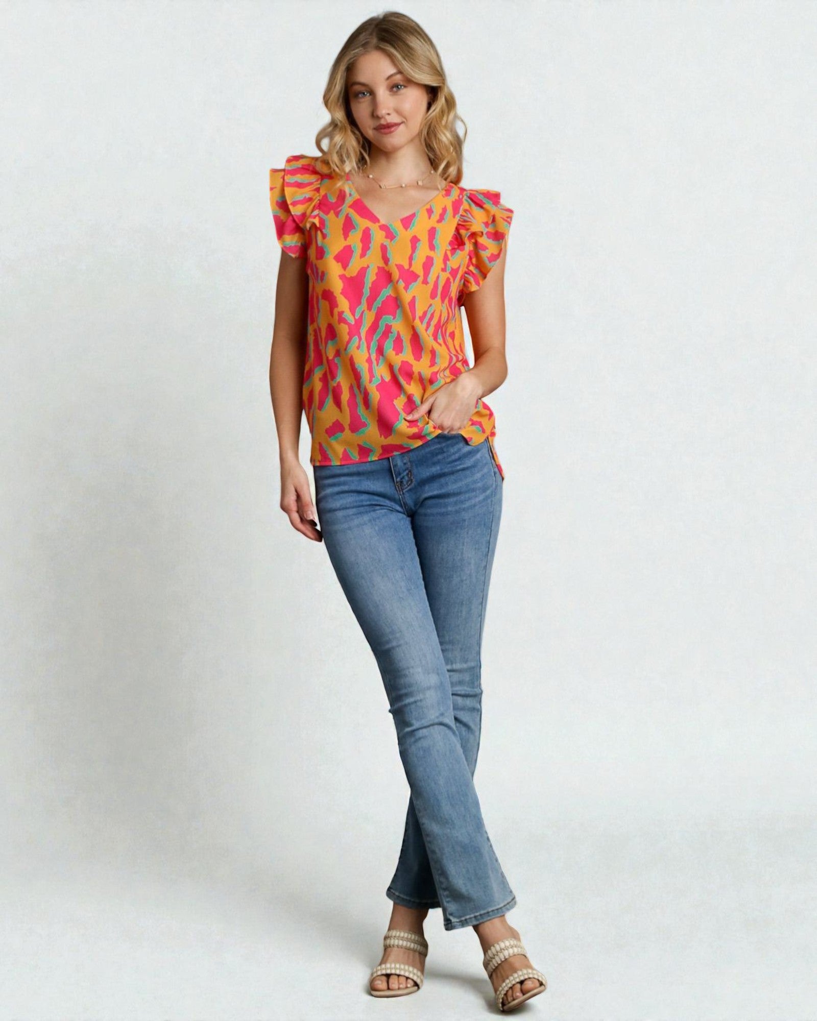 Woman wearing a colorful top and blue jeans on a white background