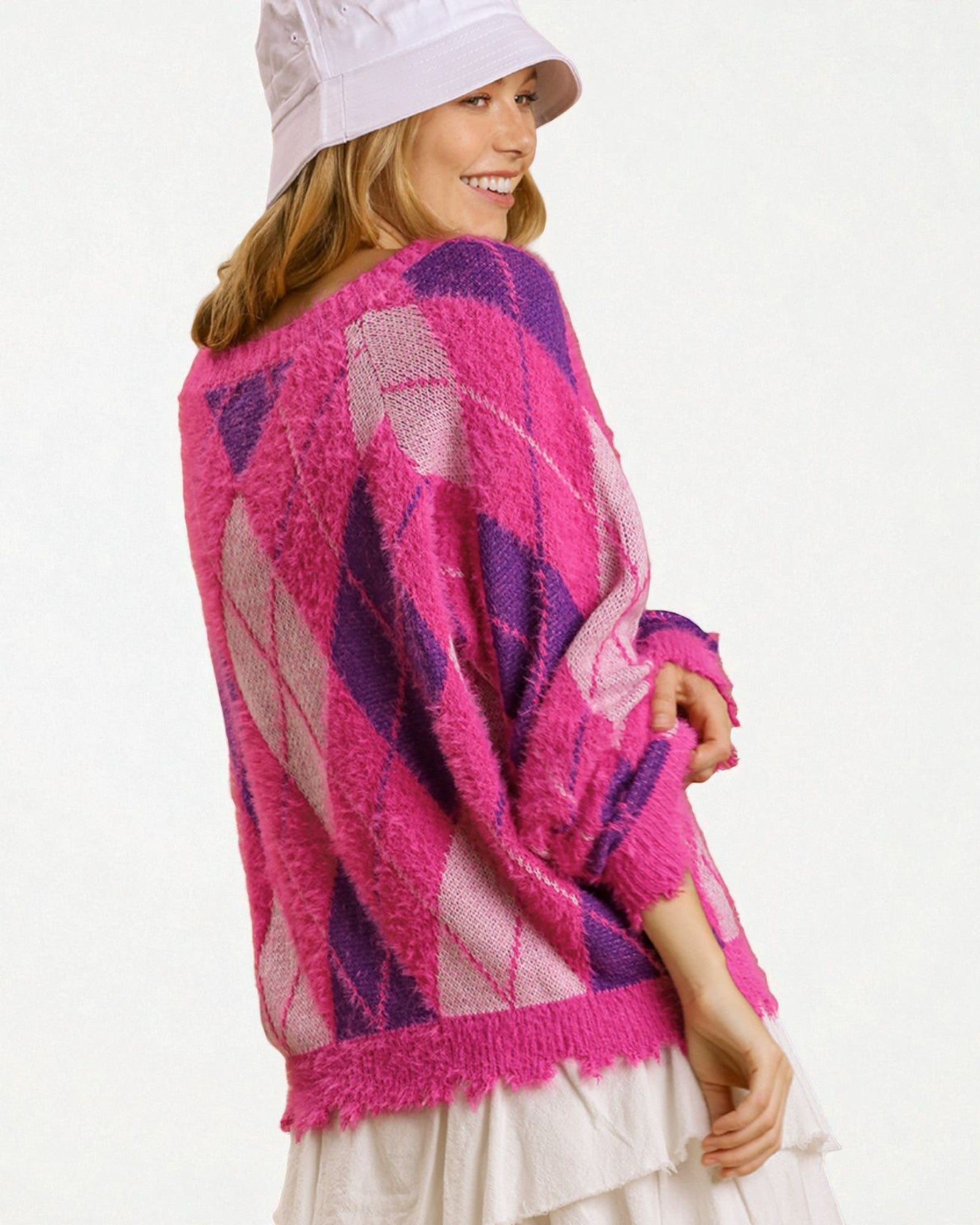 Woman wearing a pink and purple patterned sweater on a white background