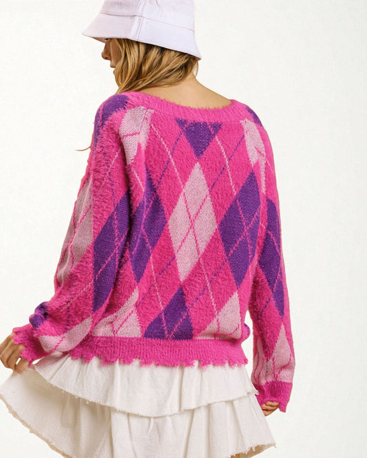 Person wearing a pink and purple argyle sweater with a white background