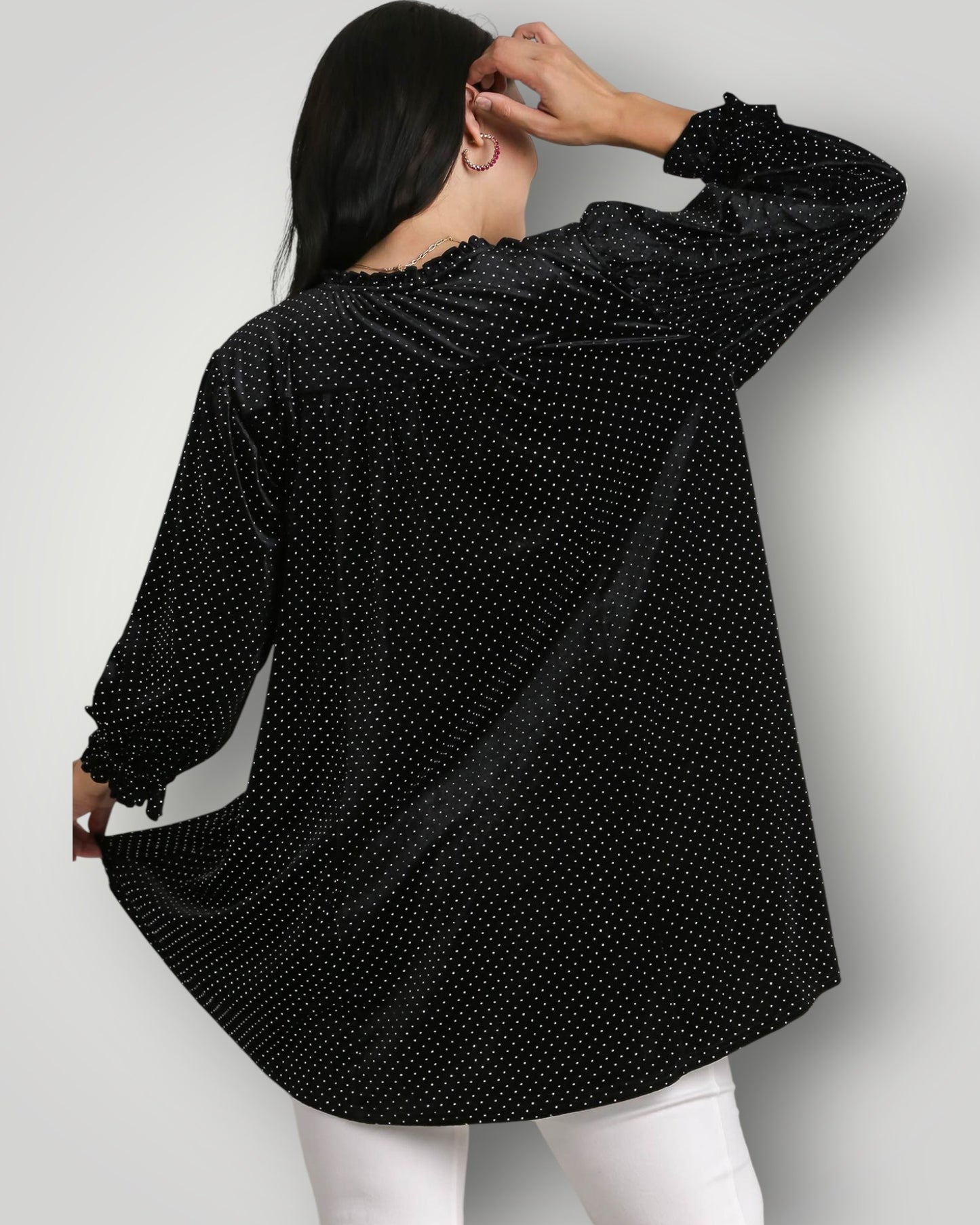 Woman wearing a black polka dot shirt on a white background