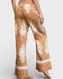 Brown pants with white embroidery on a plain background