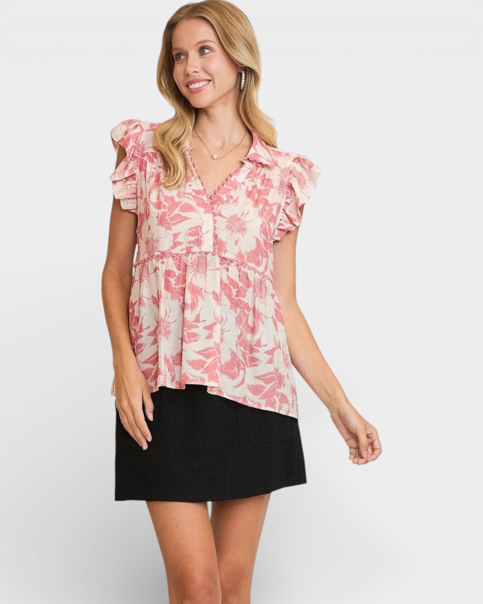 Woman wearing a pink floral blouse and black skirt on a white background