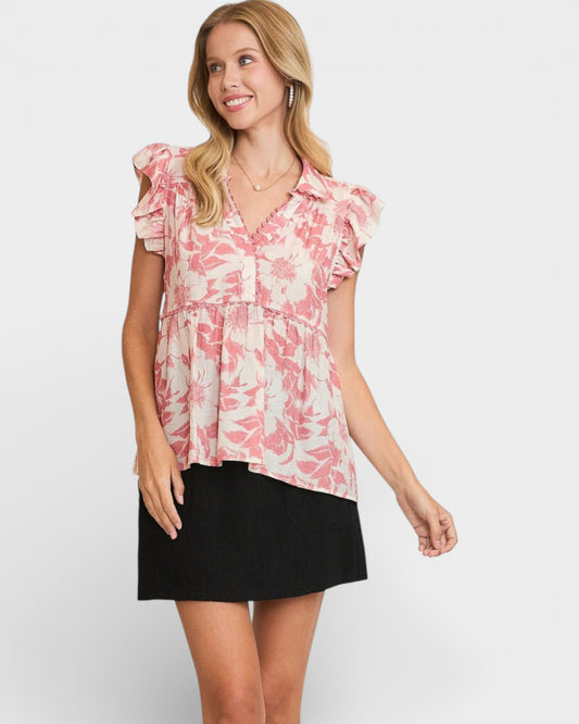 Woman wearing a pink floral blouse and black skirt on a white background