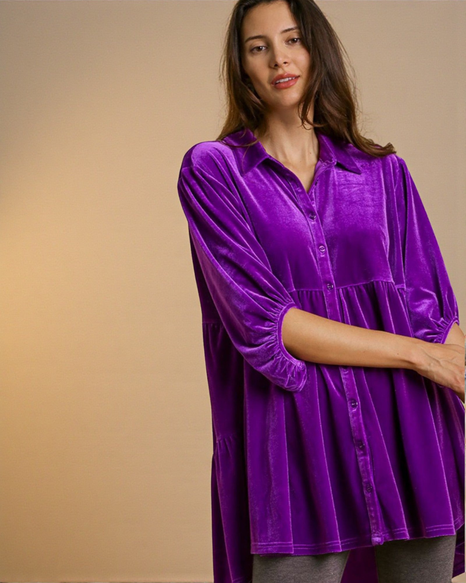Woman wearing a purple shirt against a beige background