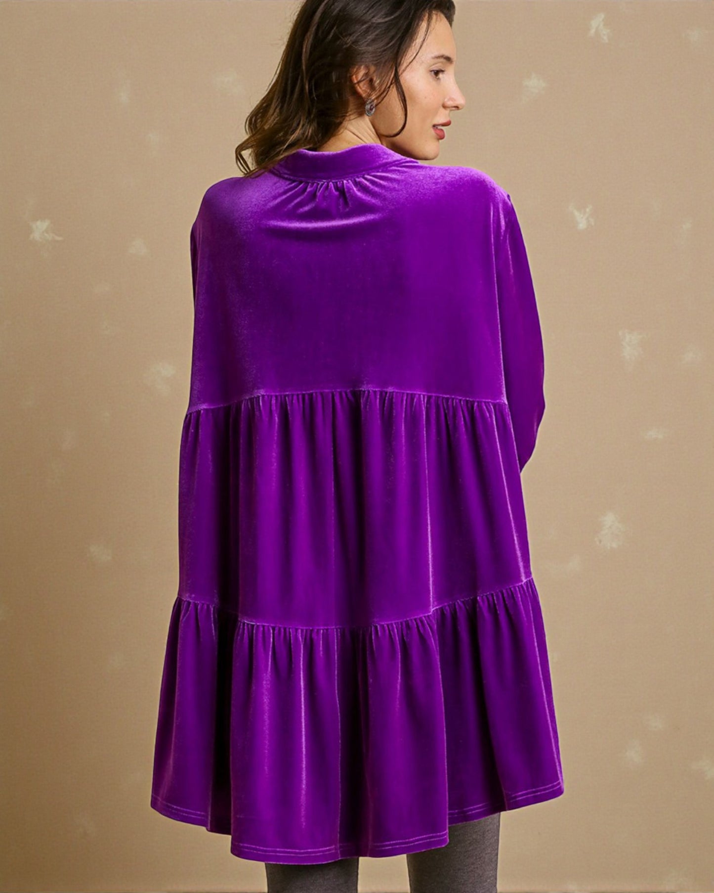 Purple velvet dress worn by a person on a beige background