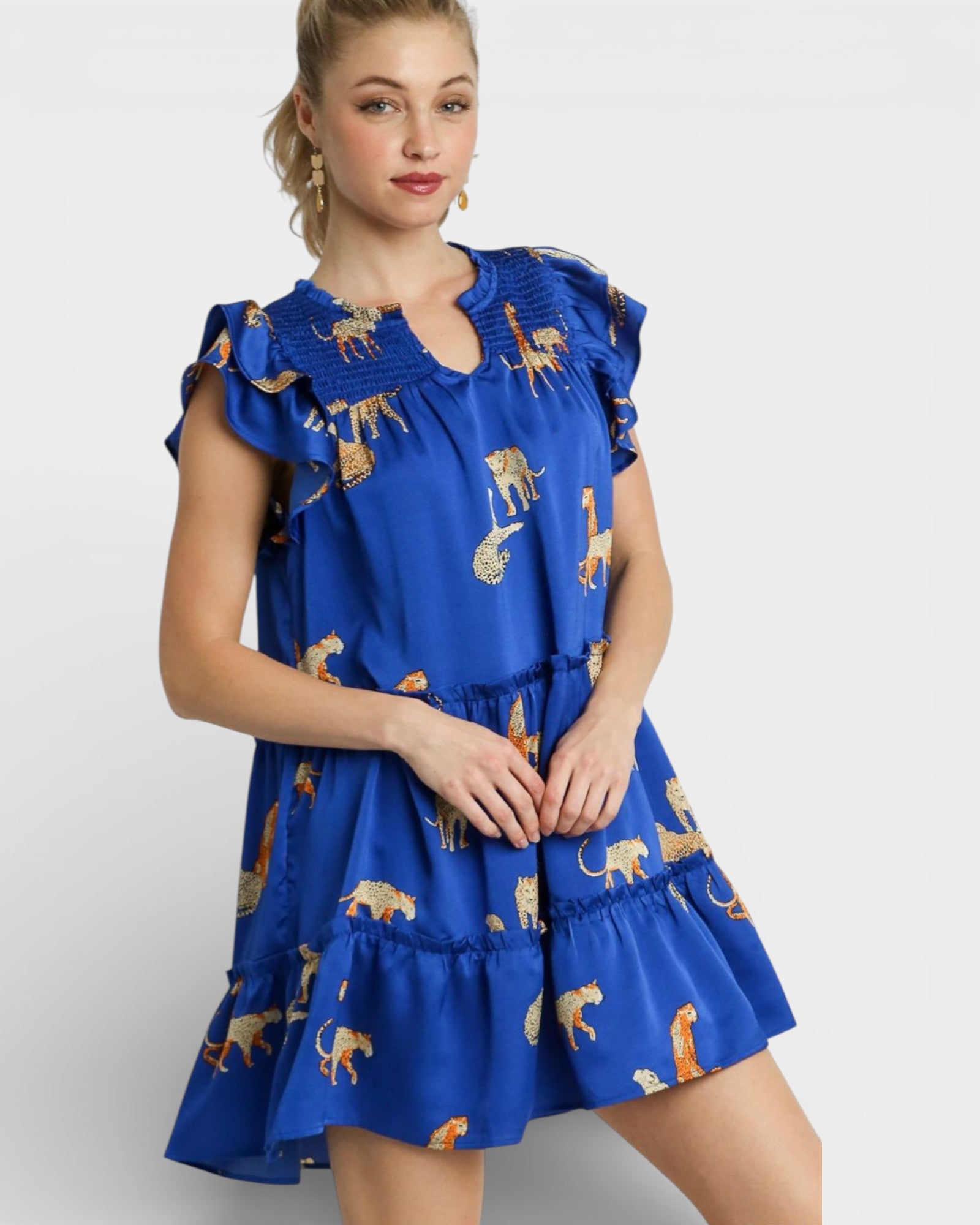 Woman wearing a blue dress with animal prints on a white background