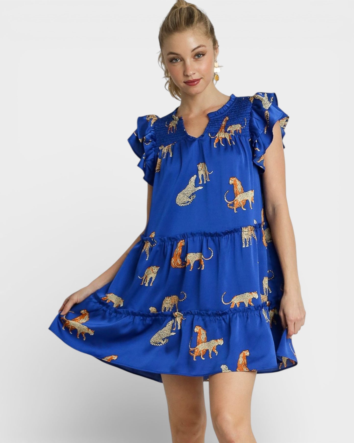 Woman wearing a blue dress with animal prints on a white background