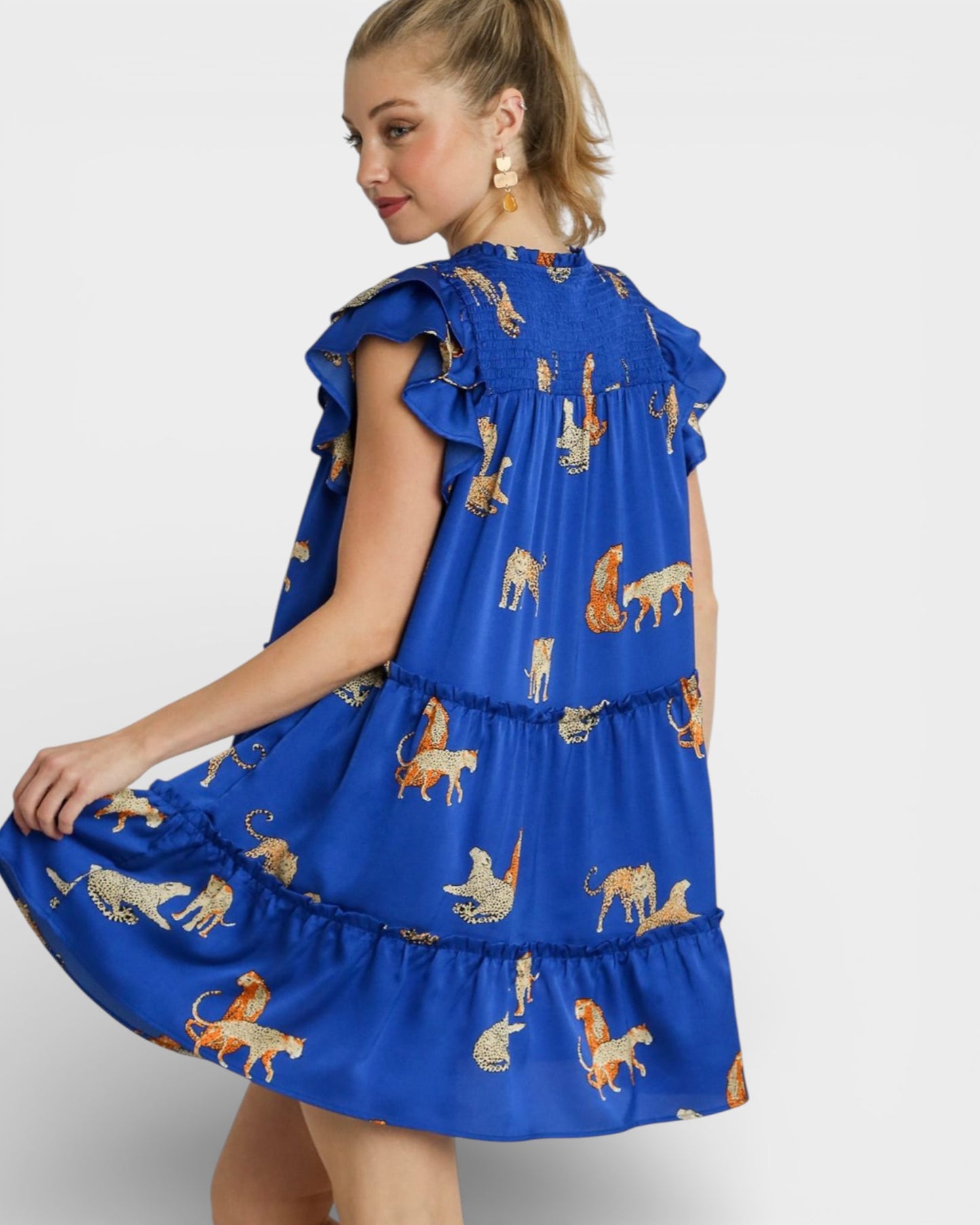 Woman wearing a blue dress with lion print on a white background