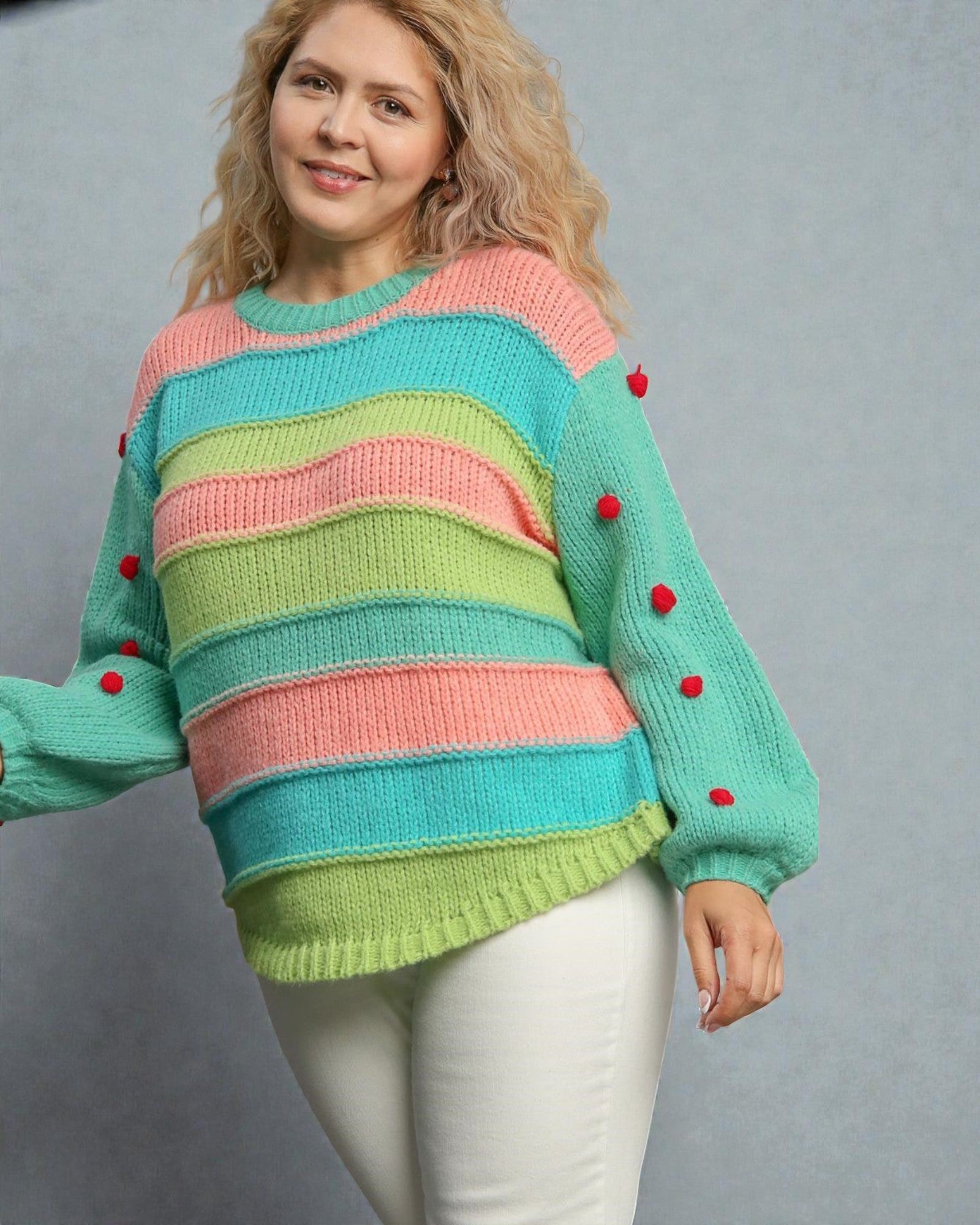 Woman wearing a colorful striped sweater with red buttons on a gray background