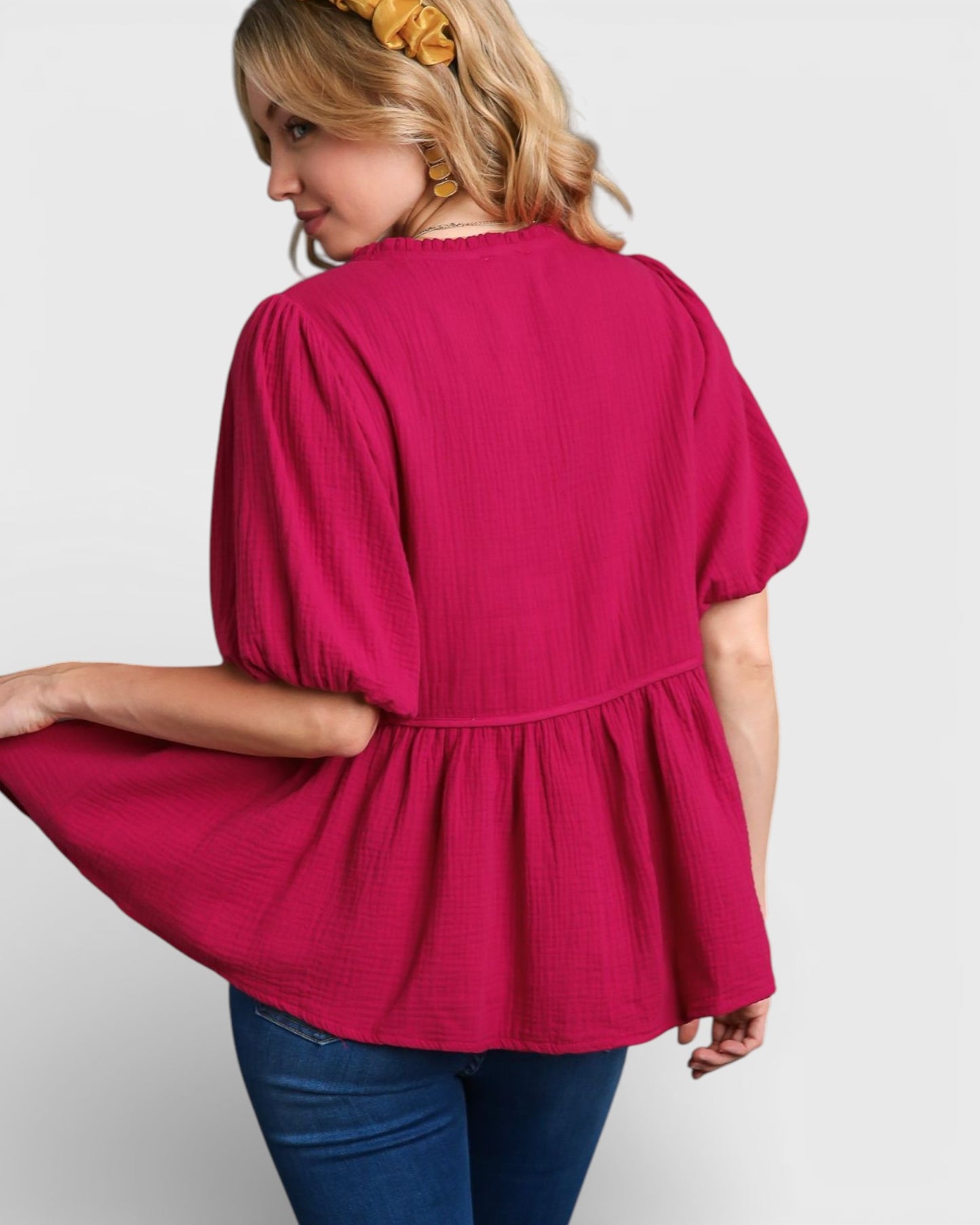 Woman wearing a pink blouse with a plain background