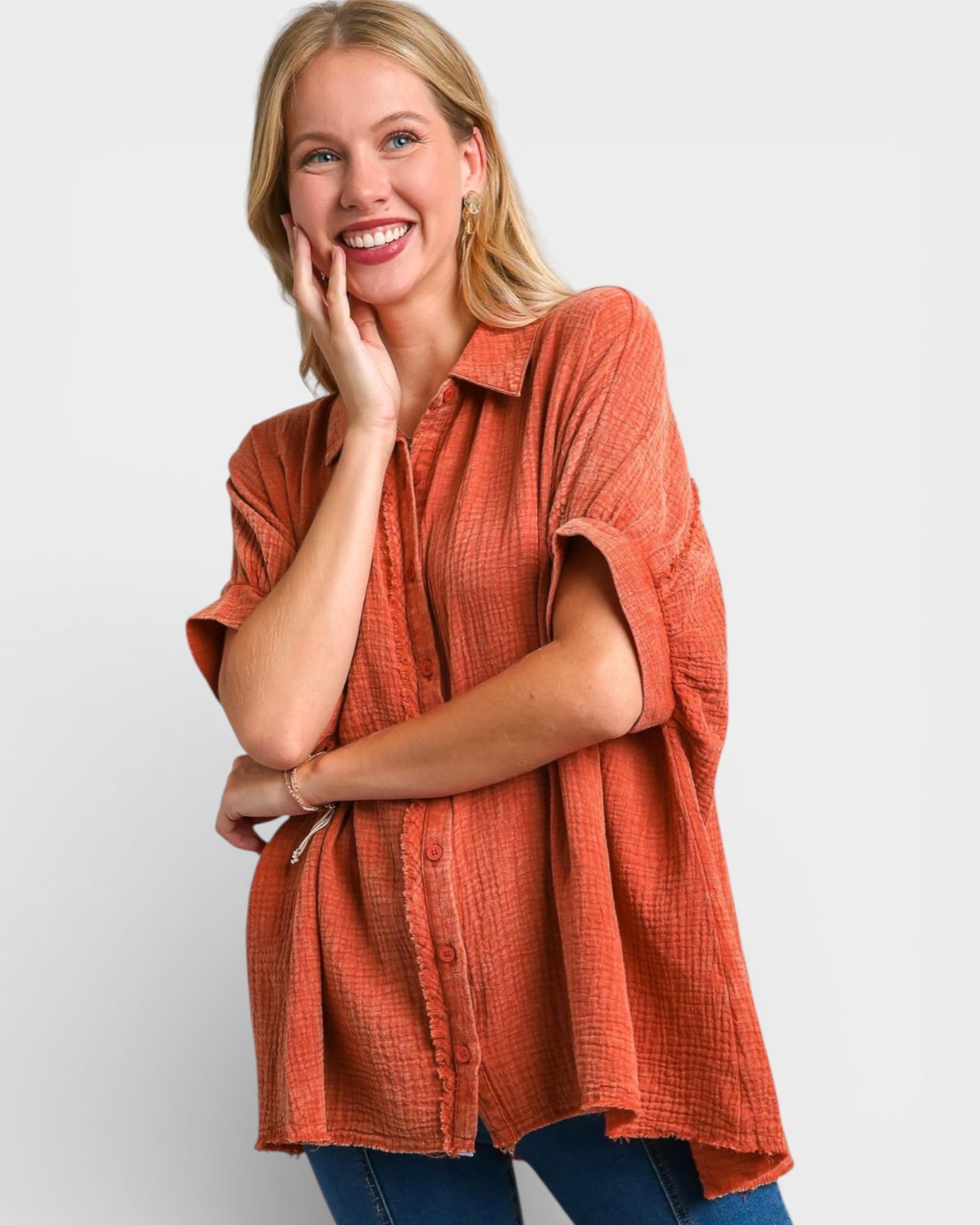 Woman wearing an orange textured shirt against a plain background