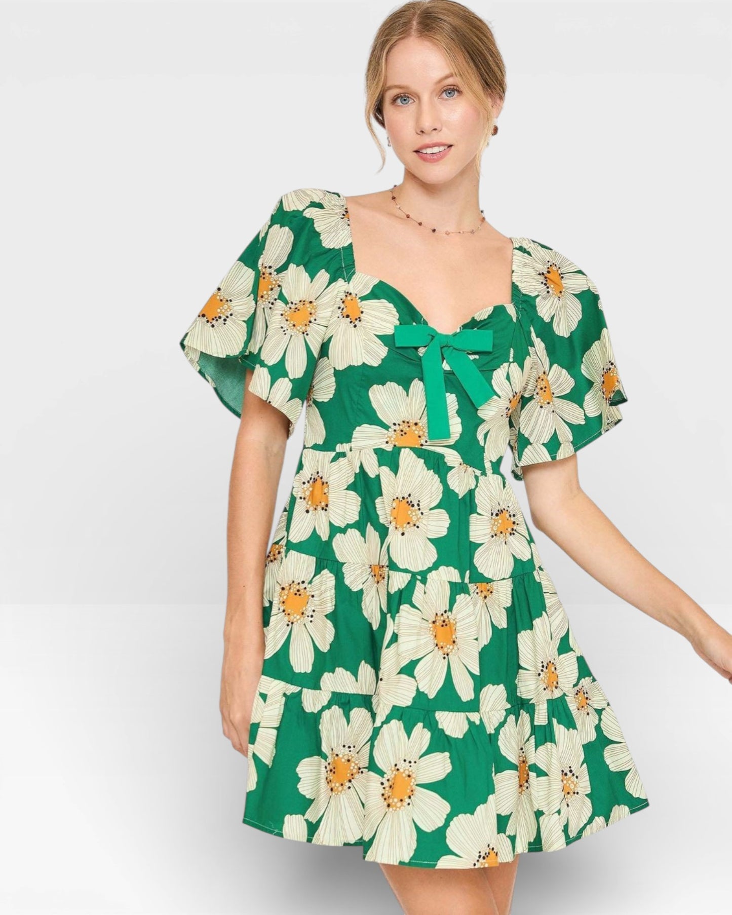 Woman wearing a green floral dress on a white background